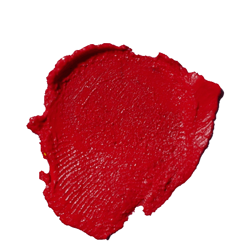 The image is a close-up of a thick, textured daub of red lipstick. The smear has a rich, vibrant hue with a glossy finish, showcasing the product's creamy consistency. The swipe of lipstick is uneven, with some areas thicker, creating a sense of depth and intensity. The background is plain white, which contrasts sharply with the red, emphasizing the color's boldness.